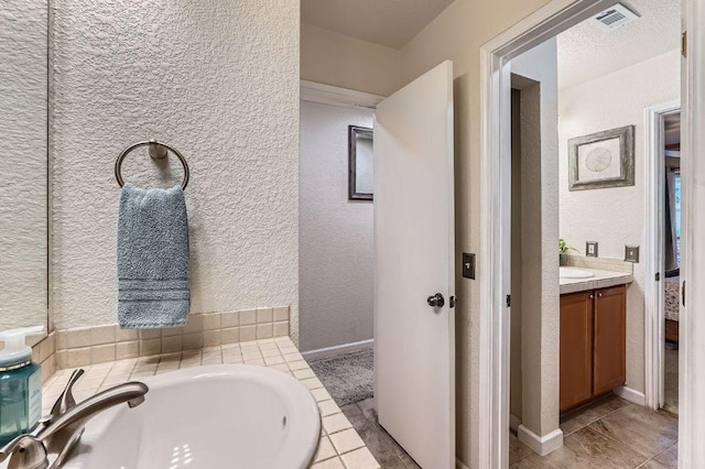 1229 Twin Cv, Kyle, TX 78640 - bathroom with vanity, a textured wall, and a garden tub