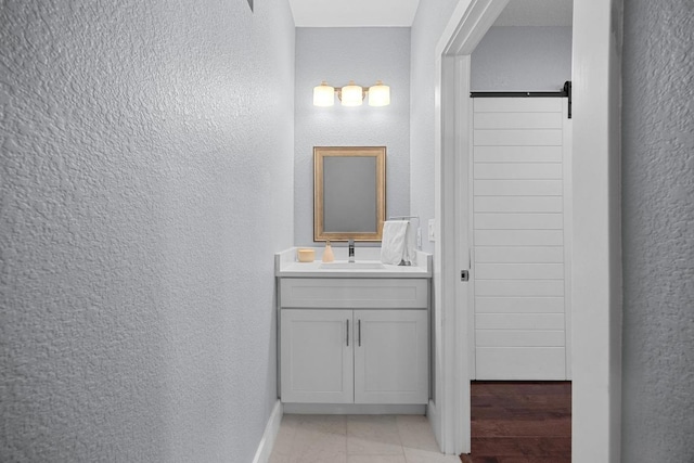 312 Delmar Ave Unit B, Austin, TX 78752 - bathroom featuring a textured wall, vanity, and tile patterned floors