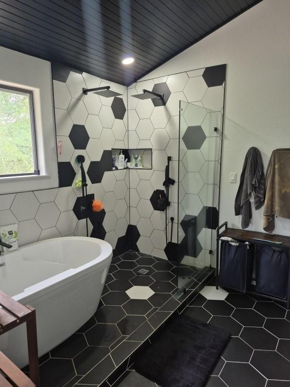 126 Deer Run Dr, Cedar Creek, TX 78612 - bathroom with a freestanding bath, a stall shower, tile patterned flooring, and tile walls