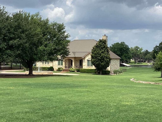 1621 Legends Pkwy, Kingsland, TX 78639 - view of front facade featuring a chimney, a front yard, and stone siding