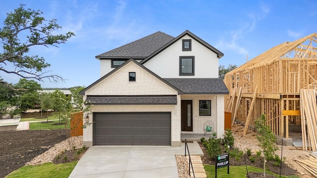 2705 Sage Ranch Dr Unit 19, Leander, TX 78641 - view of front facade with a shingled roof, concrete driveway, brick siding, a garage, and stucco siding