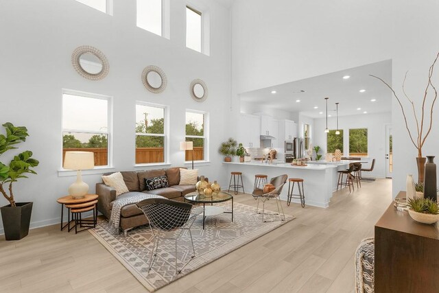 2705 Sage Ranch Dr Unit 19, Leander, TX 78641 - living area with light wood-type flooring, plenty of natural light, a towering ceiling, and recessed lighting