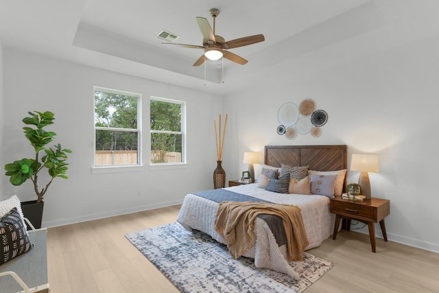 2705 Sage Ranch Dr Unit 19, Leander, TX 78641 - bedroom featuring light wood-type flooring, a raised ceiling, and a ceiling fan
