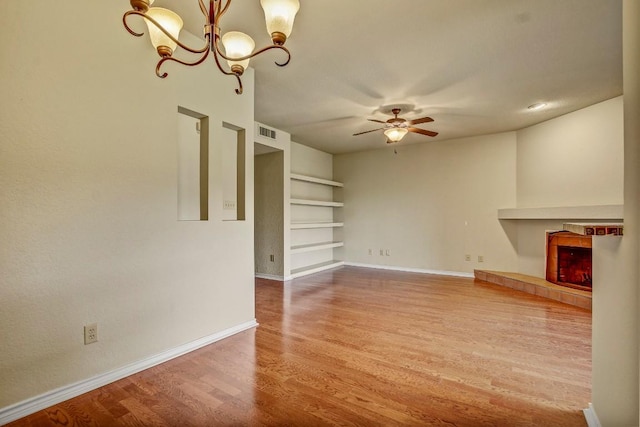 8200 Neely Dr Unit 116, Austin, TX 78759 - unfurnished living room with ceiling fan, wood finished floors, a tiled fireplace, built in shelves, and a chandelier