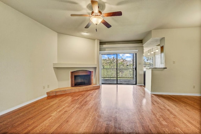 8200 Neely Dr Unit 116, Austin, TX 78759 - unfurnished living room with ceiling fan, a tile fireplace, and wood finished floors