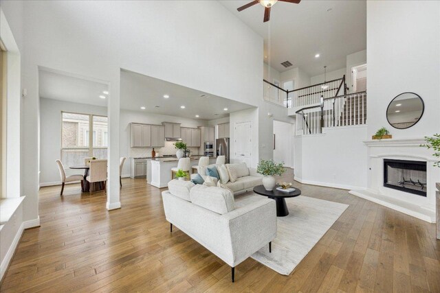 19612 Abigail Way, Pflugerville, TX 78660 - living area featuring a high ceiling, a ceiling fan, light wood-style flooring, recessed lighting, and a fireplace with raised hearth