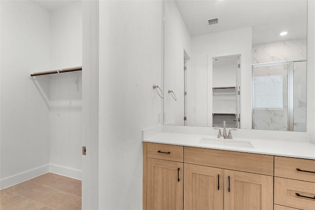 20500 Ed Townes Ter, Manor, TX 78653 - bathroom featuring a walk in closet, vanity, a marble finish shower, and tile patterned floors