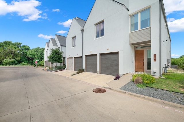 2608 Watkins Way, Austin, TX 78746 - view of front of property featuring a garage, concrete driveway, and stucco siding