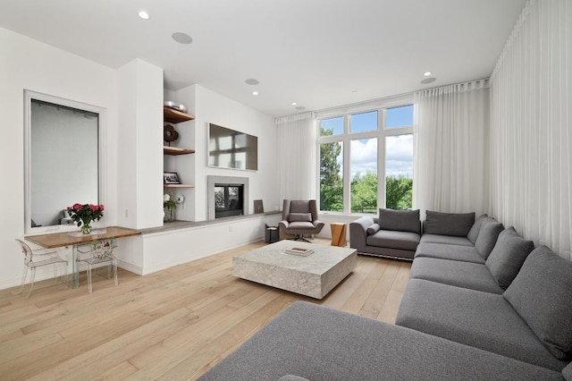 2608 Watkins Way, Austin, TX 78746 - living room with light wood-type flooring, built in shelves, a glass covered fireplace, and recessed lighting