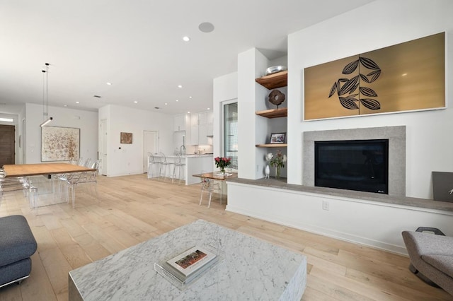 2608 Watkins Way, Austin, TX 78746 - living area featuring light wood-style floors, a glass covered fireplace, recessed lighting, and built in shelves