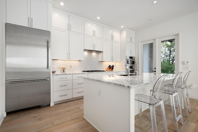2608 Watkins Way, Austin, TX 78746 - kitchen featuring high end fridge, light wood-type flooring, decorative backsplash, recessed lighting, and white cabinets