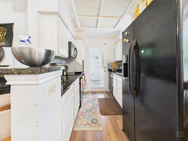 3111 Tom Green St Unit 208, Austin, TX 78705 - kitchen with black appliances, light wood finished floors, dark countertops, and white cabinets