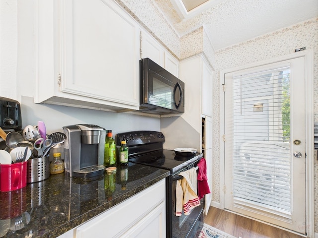 3111 Tom Green St Unit 208, Austin, TX 78705 - kitchen featuring black appliances, white cabinetry, wood finished floors, dark stone countertops, and wallpapered walls