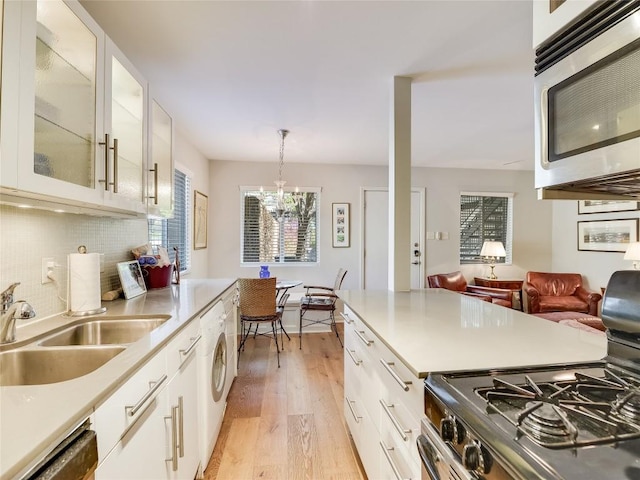 1503 W 9th St Unit 106, Austin, TX 78703 - kitchen with stainless steel microwave, gas range, dishwashing machine, light wood-style flooring, and washer / clothes dryer