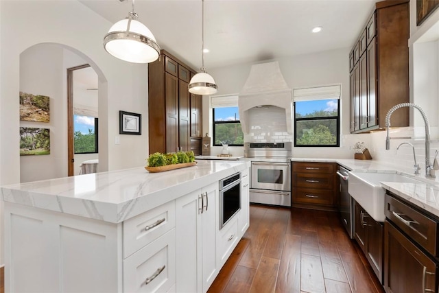 1404 Hurst Creek Rd, Austin, TX 78734 - kitchen featuring appliances with stainless steel finishes, light stone countertops, dark wood-style floors, a center island, and recessed lighting