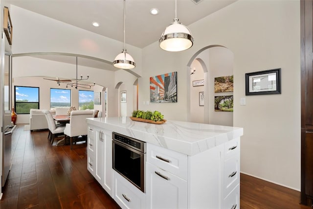 1404 Hurst Creek Rd, Austin, TX 78734 - kitchen with arched walkways, dark wood-style flooring, open floor plan, recessed lighting, and light stone counters