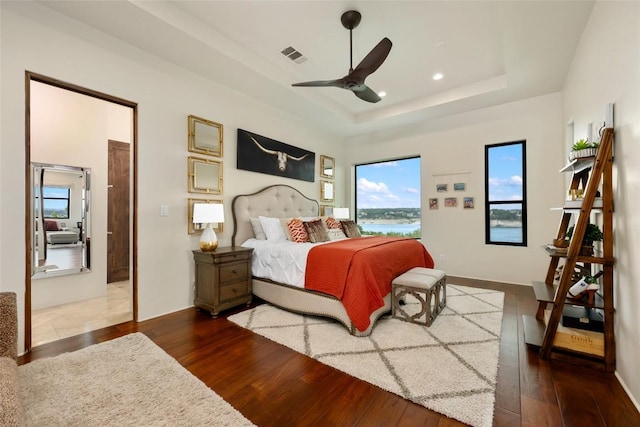 1404 Hurst Creek Rd, Austin, TX 78734 - bedroom featuring wood finished floors, a tray ceiling, a water view, recessed lighting, and ceiling fan