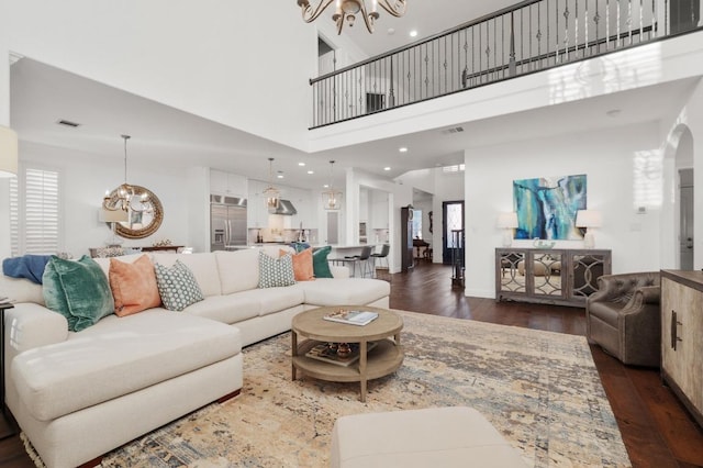11208 Woodland Hills Trl, Austin, TX 78732 - living area featuring a chandelier, dark wood-style floors, arched walkways, and a high ceiling