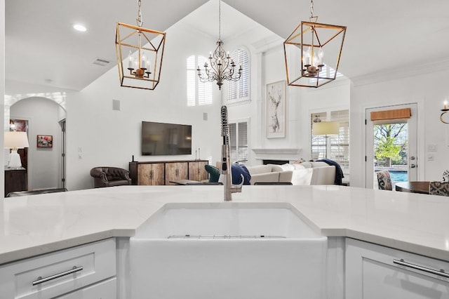 11208 Woodland Hills Trl, Austin, TX 78732 - kitchen featuring a chandelier, open floor plan, high vaulted ceiling, hanging light fixtures, and white cabinets