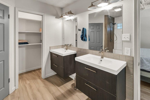 3705 Peach Vista Dr, Pflugerville, TX 78660 - full bath featuring wood finished floors, two vanities, backsplash, and a shower