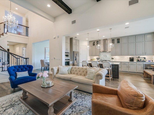 6701 Denia Dr, Austin, TX 78739 - living room with wood finished floors, stairway, a chandelier, a high ceiling, and recessed lighting