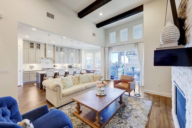 6701 Denia Dr, Austin, TX 78739 - living area featuring beamed ceiling, wood finished floors, a fireplace, a towering ceiling, and recessed lighting