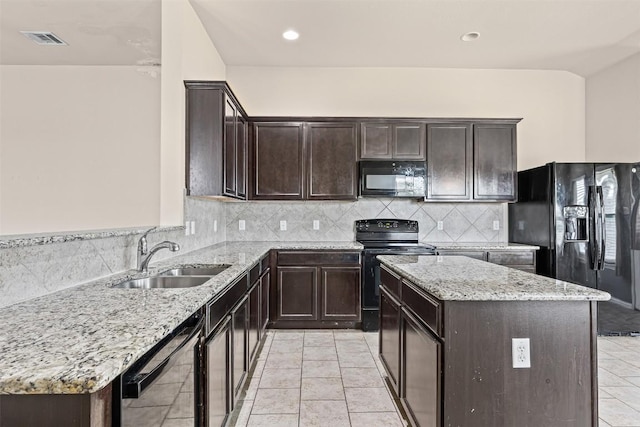4019 Brookhaven Dr, Temple, TX 76504 - kitchen featuring black appliances, light stone counters, a center island, dark brown cabinetry, and recessed lighting