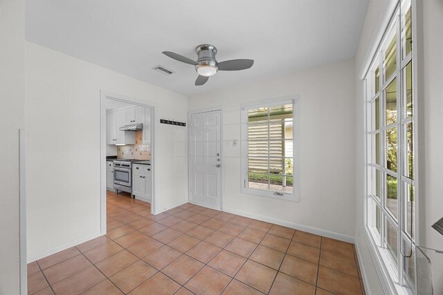 1807 W Saint Johns Ave, Austin, TX 78757 - spare room featuring healthy amount of natural light, ceiling fan, and light tile patterned flooring