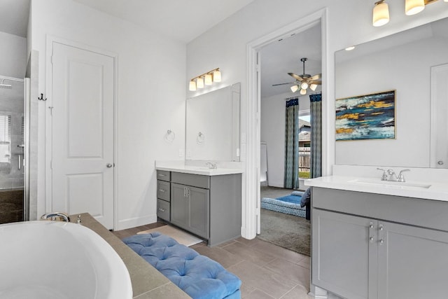 14521 Kira Ln, Manor, TX 78653 - bathroom with two vanities, a ceiling fan, a shower stall, and a bathtub