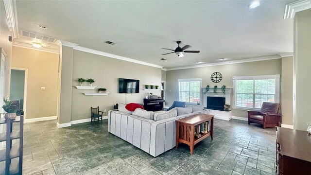 1127 Robin Rd, Elgin, TX 78621 - living area with stone tile floors, ceiling fan, a fireplace with raised hearth, crown molding, and recessed lighting