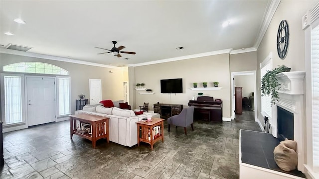 1127 Robin Rd, Elgin, TX 78621 - living area featuring ceiling fan, a fireplace with raised hearth, ornamental molding, and stone tile floors