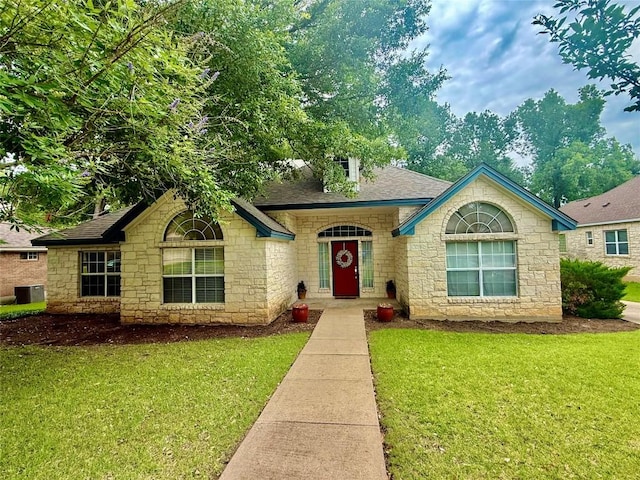 1127 Robin Rd, Elgin, TX 78621 - view of front facade featuring stone siding, a front lawn, and roof with shingles