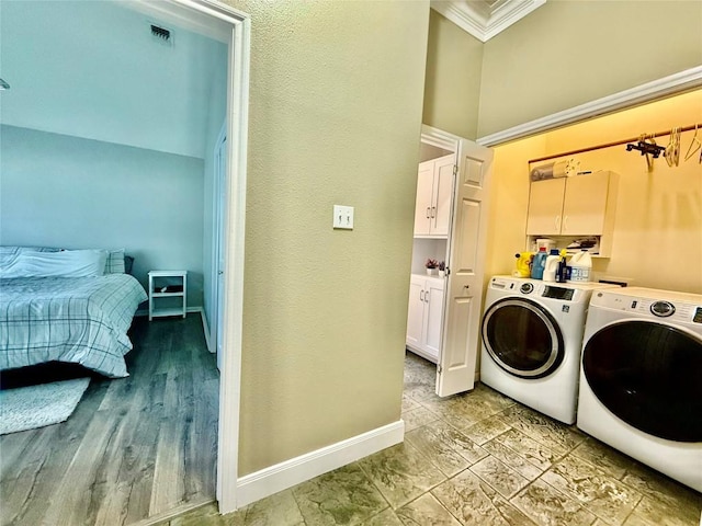 1127 Robin Rd, Elgin, TX 78621 - laundry area featuring independent washer and dryer, ornamental molding, and cabinet space