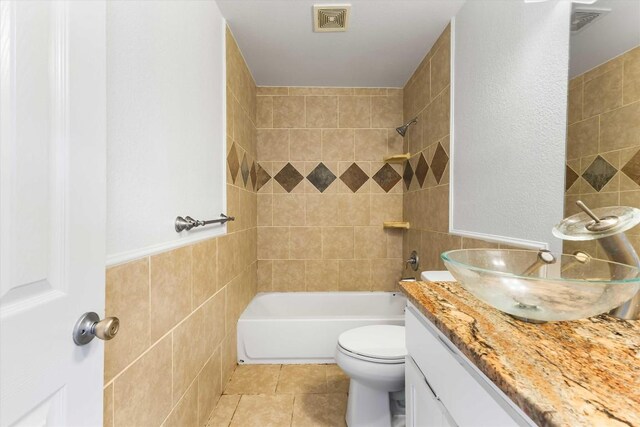 12212 Ballerstedt Rd, Elgin, TX 78621 - full bathroom with vanity, tile walls, tile patterned floors, and shower / bathtub combination