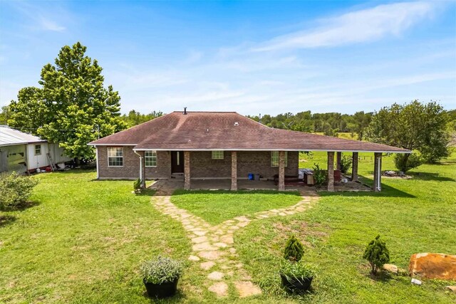 12212 Ballerstedt Rd, Elgin, TX 78621 - rear view of house featuring a patio area, a yard, and a shingled roof