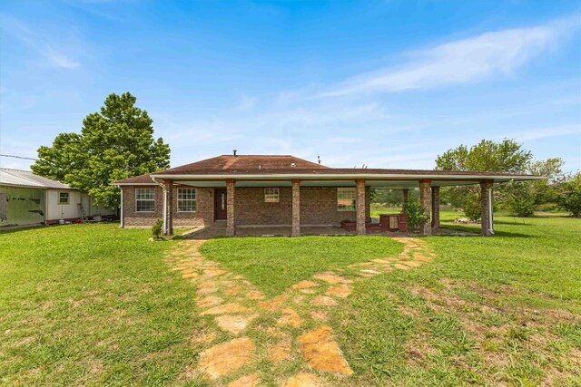 12212 Ballerstedt Rd, Elgin, TX 78621 - rear view of house with a lawn and brick siding