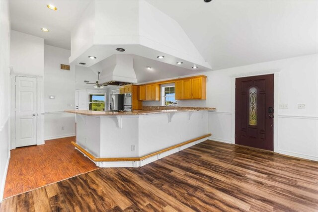 12212 Ballerstedt Rd, Elgin, TX 78621 - kitchen with a peninsula, wood finished floors, high vaulted ceiling, a breakfast bar, and recessed lighting
