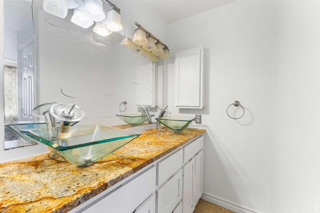 12212 Ballerstedt Rd, Elgin, TX 78621 - bathroom featuring double vanity and baseboards