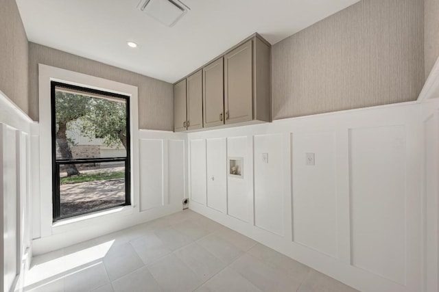 10507 Spicewood Pkwy, Austin, TX 78750 - laundry area featuring a decorative wall, cabinet space, light tile patterned floors, washer hookup, and wainscoting