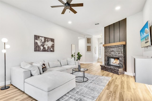 405 Alva Dr, Spicewood, TX 78669 - living area featuring ceiling fan, light wood-style floors, a stone fireplace, and recessed lighting