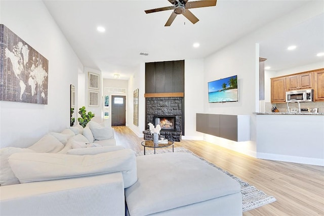 405 Alva Dr, Spicewood, TX 78669 - living room featuring light wood-type flooring, ceiling fan, recessed lighting, and a fireplace