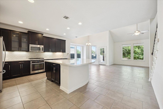 123 Pond View Pass, Buda, TX 78610 - kitchen featuring stainless steel appliances, healthy amount of natural light, decorative backsplash, light countertops, and vaulted ceiling