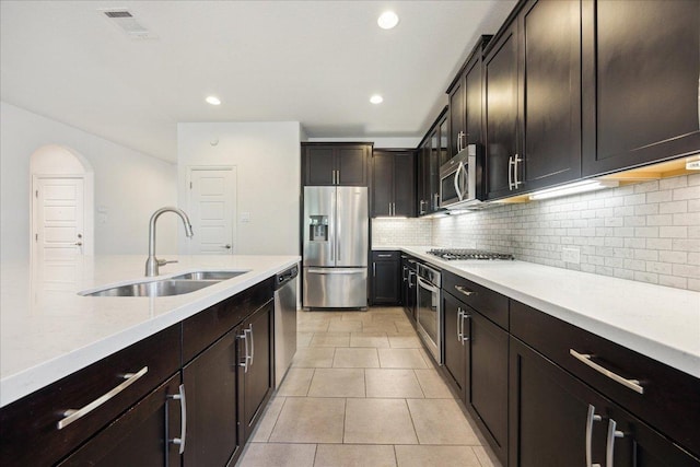 123 Pond View Pass, Buda, TX 78610 - kitchen with appliances with stainless steel finishes, backsplash, dark brown cabinets, light tile patterned floors, and recessed lighting