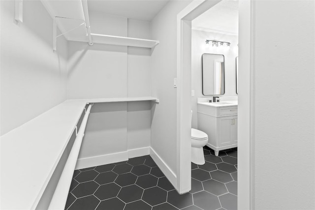 3907 Carmel Dr, Austin, TX 78721 - spacious closet featuring a sink and dark tile patterned floors