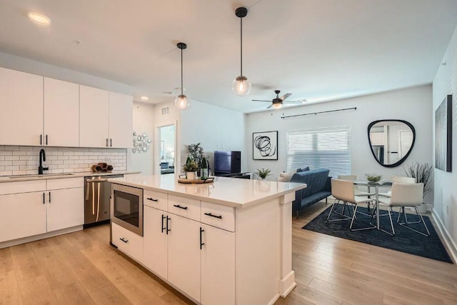 3101 Govalle Ave Unit 103, Austin, TX 78702 - kitchen featuring dishwasher, light wood-style floors, light countertops, tasteful backsplash, and recessed lighting