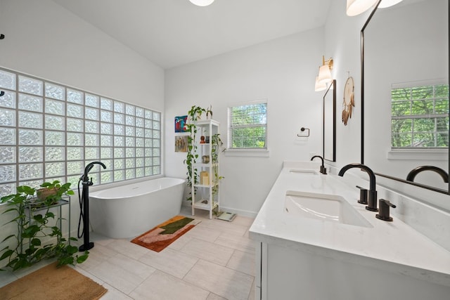 703 Stagecoach Trl, San Marcos, TX 78666 - bathroom featuring double vanity, a soaking tub, and tile patterned flooring