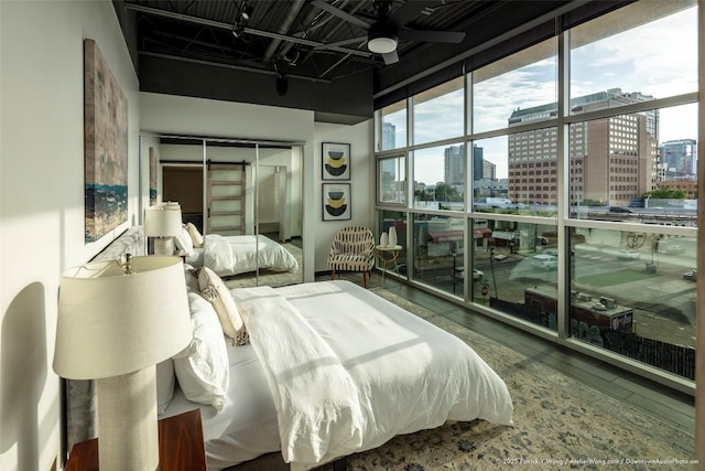 601 Brushy St Unit 106, Austin, TX 78702 - bedroom featuring a city view, a wall of windows, wood finished floors, a towering ceiling, and a closet