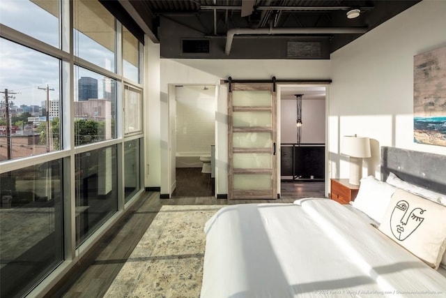 601 Brushy St Unit 106, Austin, TX 78702 - bedroom with wood finished floors, a barn door, and a view of city