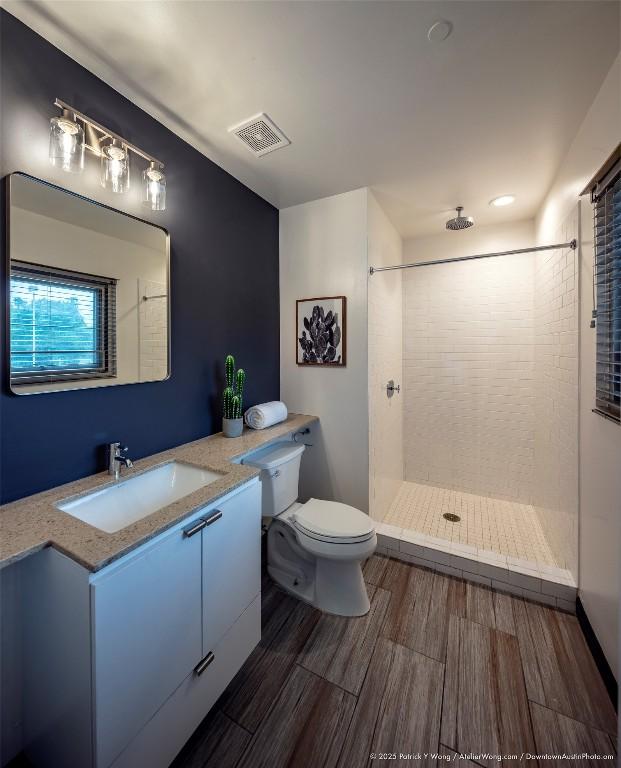601 Brushy St Unit 106, Austin, TX 78702 - bathroom featuring vanity, tiled shower, and wood finished floors