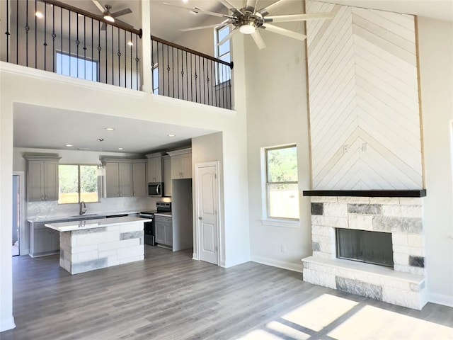 142 E Pauwela Ln, Bastrop, TX 78602 - kitchen featuring gray cabinets, ceiling fan, stainless steel appliances, a high ceiling, and open floor plan